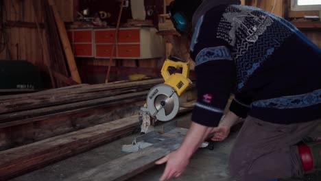 The-Man-is-Utilizing-a-Circular-Saw-to-Trim-the-Wooden-Plank-Required-for-Building-the-Hot-Tub---Close-Up