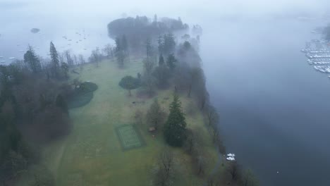 Drone-panning-from-the-left-to-the-right-side-of-the-frame-over-the-lakeside-town-of-Bowness-on-Windermere,-located-in-the-district-of-Furness,-in-Cumbria-in-England