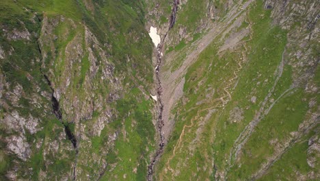 Valea-rea-in-the-fagaras-mountains-with-rugged-terrain-and-trails,-during-daylight,-aerial-view