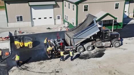 Workers-pave-new-parking-lot-beside-a-spacious-barn-on-a-crisp-autumn-day