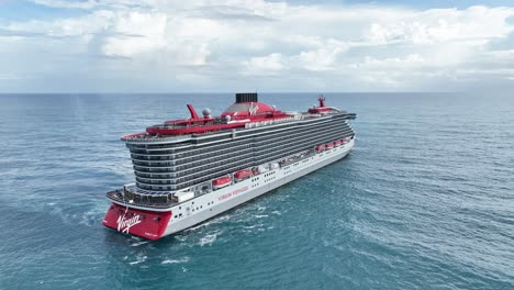 Flying-over-large-cruise-ship-navigating-in-open-ocean