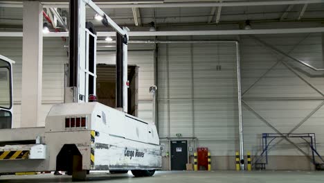 White-tug-master-vehicle-parked-inside-an-industrial-warehouse,-ambient-lighting,-no-people