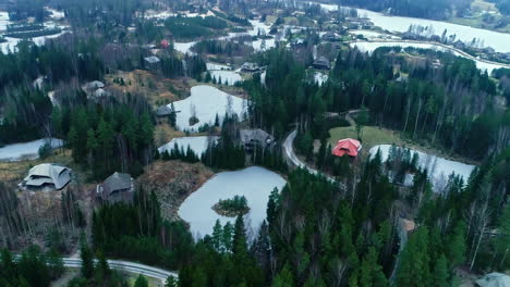 Mountain-resort-log-cabins-in-the-woods-close-to-sky-slope-aerial-nature-landscape