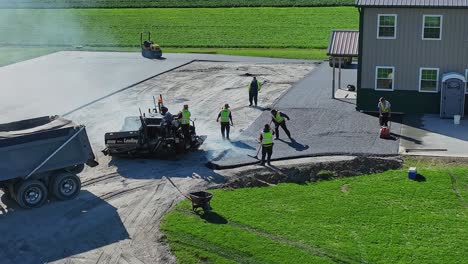 Un-Equipo-Repavimenta-Hábilmente-Una-Carretera,-El-Sol-De-La-Mañana-Proyecta-Largas-Sombras-A-Medida-Que-Comienza-Un-Nuevo-Día.