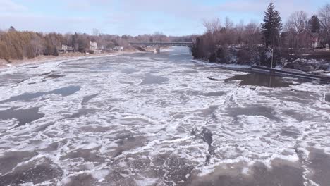 Southamptons-Vereister-Fluss-Mit-Umgebender-Winterlandschaft,-Eine-Brücke-In-Der-Ferne,-Luftaufnahme