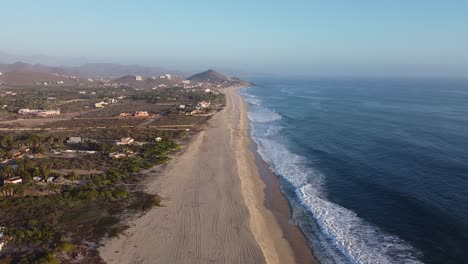 Baja-California-Sur-Langer-Sandstrand-Schützt-üppige-Palmen-Und-Häuser-Vor-Den-Wellen-Des-Pazifischen-Ozeans