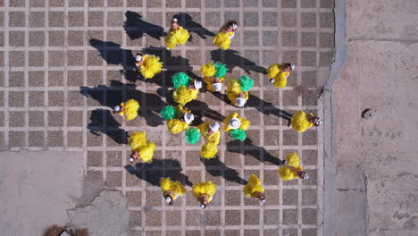 Toma-De-Arriba-Hacia-Abajo-Con-Drones-De-Chicas-Majorettes-Con-Uniformes-Amarillos-Y-Pompones