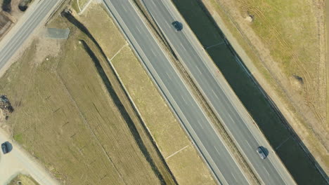 Top-down-aerial-view-of-cars-driving-on-a-straight-stretch-of-highway