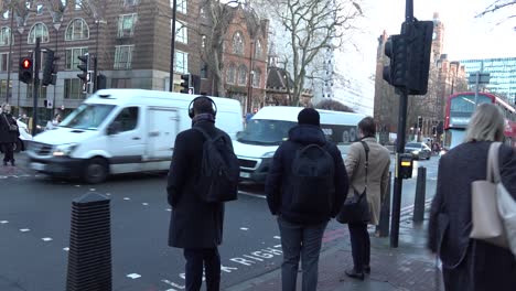 People-wait-to-cross-the-road-on-their-way-to-work-in-Westminster,-London,-UK