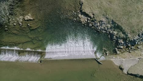 Eine-Luftaufnahme-Von-Unten-Auf-Einen-Künstlichen-Wasserfall-Für-Eine-Mühle-An-Einem-Sonnigen-Tag