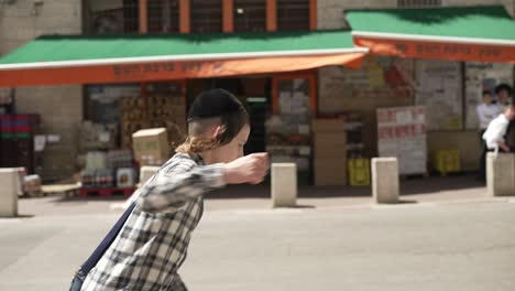 A-jewish-kid-runing-in-the-street-side-veiw