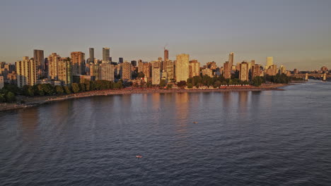 Vancouver-BC-Canada-Aerial-v59-drone-flyover-the-water-capturing-crowds-at-popular-English-bay-beach-and-seawall-promenade,-West-End-cityscape-at-sunset---Shot-with-Mavic-3-Pro-Cine---July-2023