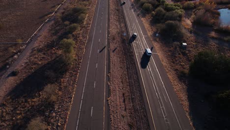 Luftaufnahme-Des-Verkehrs-Auf-Der-Arizona-State-Route-Bei-Sonnenuntergang,-Landschaft,-Autos-Und-Rissigem-Asphalt,-Drohnenaufnahme