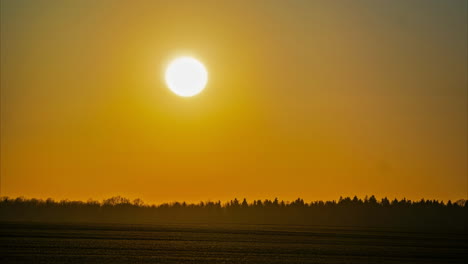 A-Medida-Que-Pasa-El-Tiempo,-El-Sol-Anaranjado-Brillante-Se-Esconde-Detrás-De-Las-Nubes.