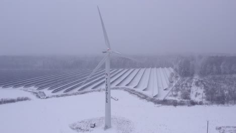 Aerial-close-up-shot-on-wind-turbine-working-is-frosty-and-snowy-weather-producing-electricity