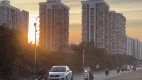 Toma-En-Primera-Persona:-Muchas-Personas-Llevan-Bicicletas-Y-Cuatro-Ruedas,-Y-En-El-Fondo-También-Se-Ven-Edificios-De-Gran-Altura-Que-Reciben-Luz-Solar.