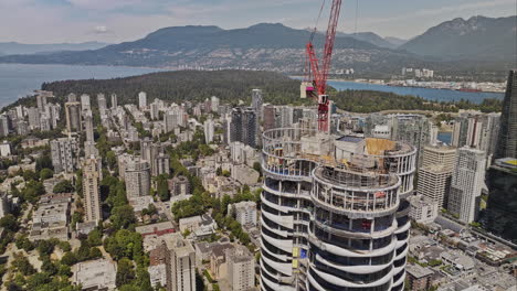 Vancouver-BC-Canada-Aerial-v110-fly-around-the-construction-crane-above-the-butterfly-residential-building-capturing-harbour,-mountain-and-downtown-cityscape---Shot-with-Mavic-3-Pro-Cine---July-2023