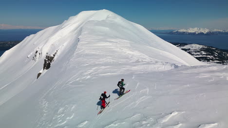 Drohnenschuss-über-Skiwanderern-Auf-Einem-Schneebedeckten-Berg,-Strahlend-Sonniger-Tag-In-Alaska