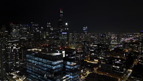 Drone-shot-rotating-in-front-of-the-Fulton-River-skyscrapers,-full-moon-in-Chicago