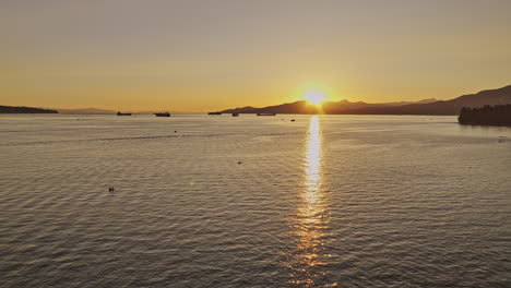 Vancouver-BC-Canada-Aerial-v58-drone-flyover-English-Bay-and-Burrard-Inlet-capturing-sunset-behind-West-mountain-with-ships-and-kayaks-on-the-calm-waters---Shot-with-Mavic-3-Pro-Cine---July-2023