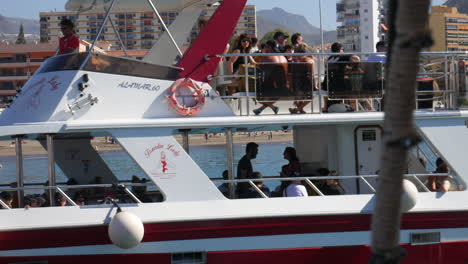Embarcaciones-De-Recreo-Modernas-Llenas-De-Turistas,-Frente-A-Un-Bullicioso-Paisaje-Urbano-Junto-A-La-Playa,-Perfectas-Para-Excursiones-En-Barco-De-Vacaciones-Y-Temas-De-Viaje.