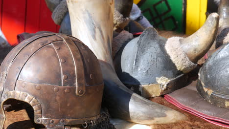 Ancient-warrior-equipment--A-Viking-helmet-and-weapons-rest-on-furs,-bringing-the-Norse-historical-era-to-life-with-palpable-authenticity