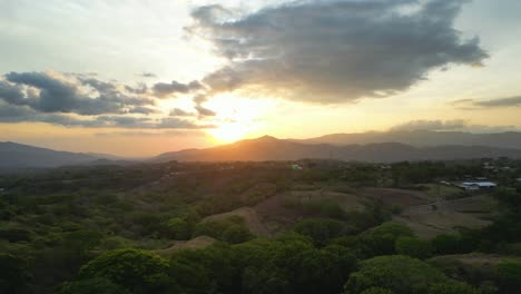 Disparo-De-Drone-Hacia-Una-Hermosa-Puesta-De-Sol-Sobre-Las-Montañas-En-El-Horizonte