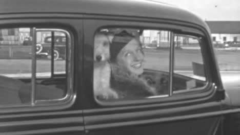 Mujer-Optimista-Sentada-En-Un-Coche-Clásico-Con-Un-Perro-En-Los-Años-1930