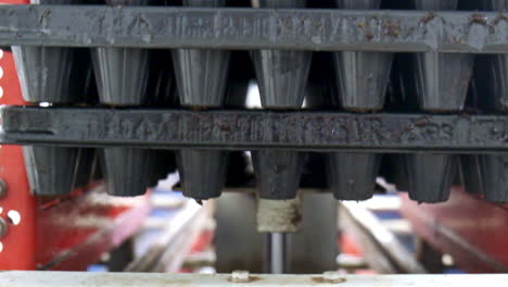 Machine-shakes-seedling-trays-and-stack-them,-telephoto-close-up