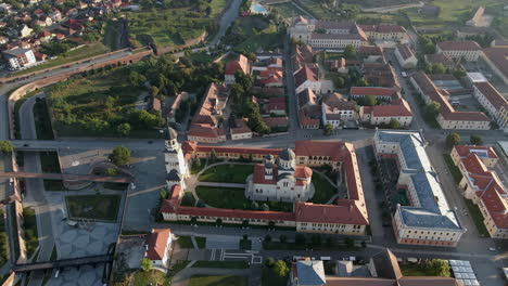 Drone-flies-closer-the-cathedral-of-Alba-Iulia,-revealing-the-city-in-the-background