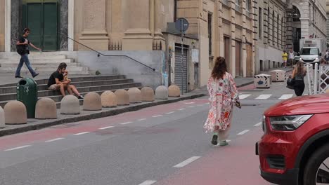 Lady-wearing-flowing-floral-clothing-walking-along-road-away-from-camera