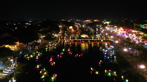 Vista-Aérea-De-Coloridos-Barcos-Linterna-Que-Salpican-El-Río-Por-La-Noche-En-Hoi-An,-Vietnam