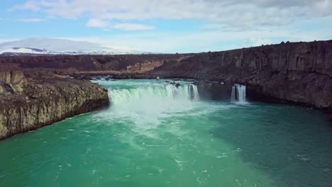 Fliegen-Sie-Durch-Die-Flussschlucht-Zum-Riesigen-Wasserfall-In-Island