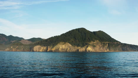 Forested-mountain-peak-on-Oregon-Coast,-from-Pacific-Ocean,-static-view