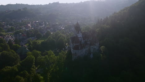 Draculas-Schloss-Im-Grellen-Morgenlicht,-Mit-Dem-Dorf-Im-Hintergrund