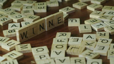 Close-up-Scrabble-tile-letters-on-edge-make-word-WINNER-on-table-top