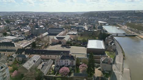 Laval-cityscape-and-Mayenne-River,-France.-Aerial-forward
