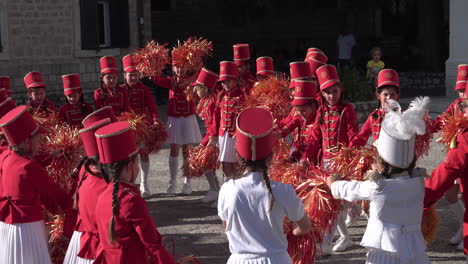 Majorettes-in-Red-Uniforms,-Group-of-Girls-With-Pom-Poms-Practicing-Choreography