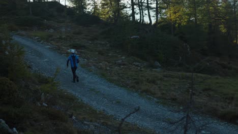 Drohne-Fliegt-Hinter-Laufendem-Mann-Her,-Um-Kamerafahrt-Auf-Bergpfad-Zu-Filmen