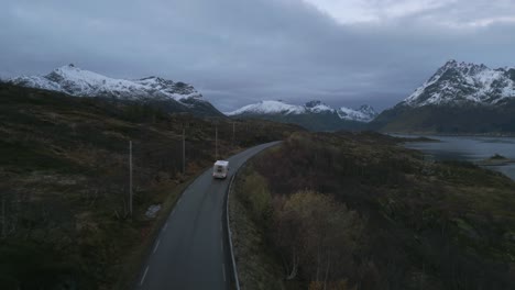 El-Crepúsculo-Desciende-Sobre-La-Carretera-De-Lofoten-Con-Una-Autocaravana-Entre-Picos-Nevados