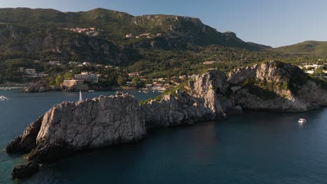 Panoramic-aerial-dolly-above-cape-in-Corfu-Greece-with-dramatic-shadows-and-light-on-landscape