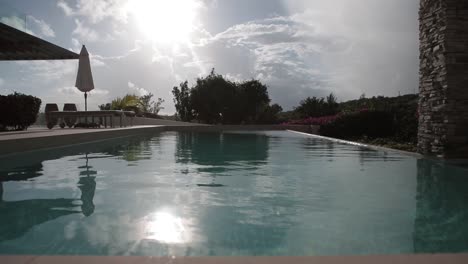 Infinity-Pool-Im-Luxuriösen-Strandresort-Des-Hotels-Mit-Sonnenreflexion-über-Dem-Wasser