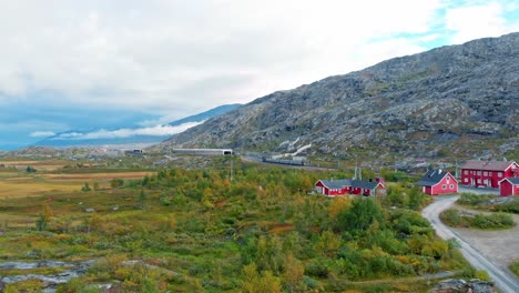 Aerial:-swedish-train-leaving-Bjørnfjell-station-in-northern-Norway-and-close-Riksgränsen,-in-the-Swedish-border