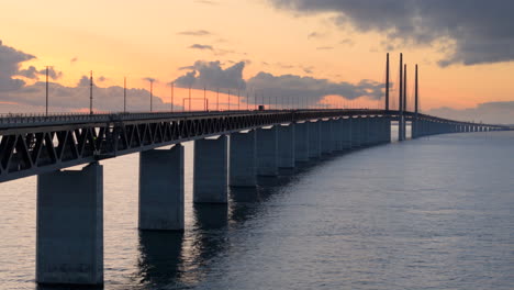 Drohnenaufnahme-In-Der-Dämmerung-An-Der-Berühmten-Öresundbrücke-Zeigt-Verkehr-Und-Zwei-Schiffe