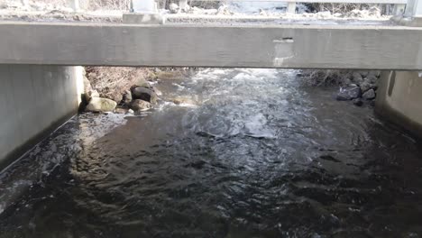 Waterfall-flowing-into-stream-beneath-bridge-in-Paradox-NY