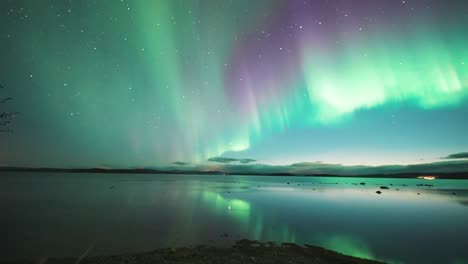 Un-Magnífico-Espectáculo-De-Luces-De-La-Aurora-Boreal-En-El-Cielo-Nocturno-Reflejado-En-Las-Tranquilas-Aguas-Del-Fiordo