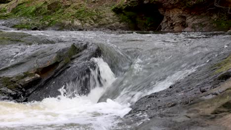 Agua-Corriendo-Sobre-Y-Alrededor-De-Rocas-En-Un-Pequeño-Arroyo-O-Río