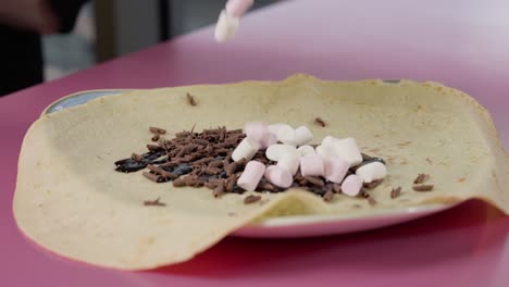 Marshmallows-Fallen-In-Zeitlupe-über-Einen-Crêpe-Mit-Schokolade