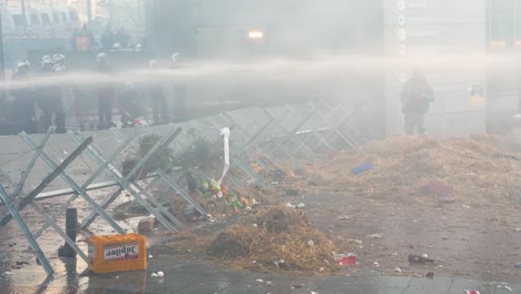 Belgische-Bereitschaftspolizei-Schützt-Das-Gebäude-Des-EU-Parlaments-Mit-Einem-Wasserschlauch-Während-Einer-Kundgebung-Wütender-Bauern-In-Brüssel,-Belgien