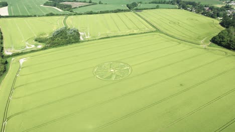 Aerial-view-descending-towards-Broad-Hilton-crop-circle-surreal-spiral-pattern-on-idyllic-Wiltshire-countryside